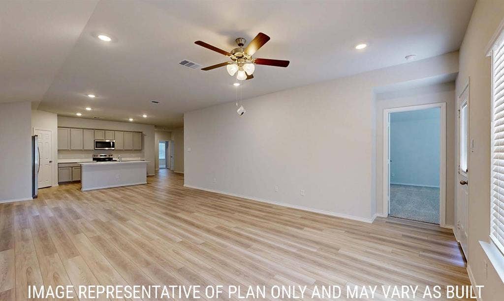 3213 Cyprian Road, Lorena, TX 76655 Open-concept interior featuring wood-finish flooring, recessed lighting, a ceiling fan with integrated lighting, and kitchen cabinetry with stainless steel appliances