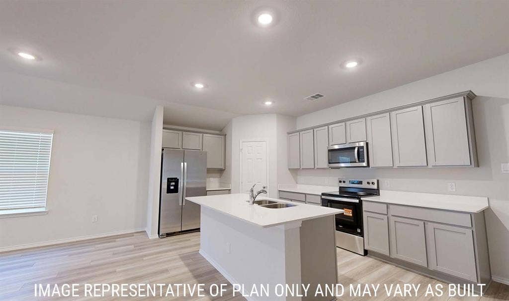 3213 Cyprian Road, Lorena, TX 76655 Kitchen featuring grey shaker-style cabinetry, white countertops, stainless steel appliances, a central island with a dual-basin sink, and wood-finish flooring