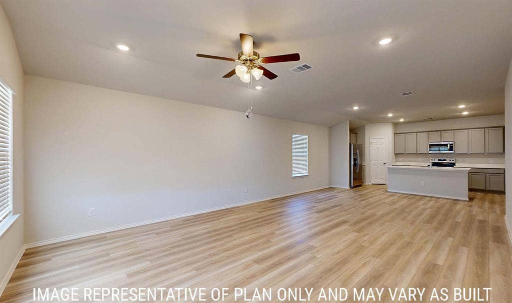 3213 Cyprian Road, Lorena, TX 76655 Open-concept interior featuring light wood-finish flooring, recessed lighting, a ceiling fan with integrated lighting, and a kitchen equipped with cabinetry and a breakfast bar