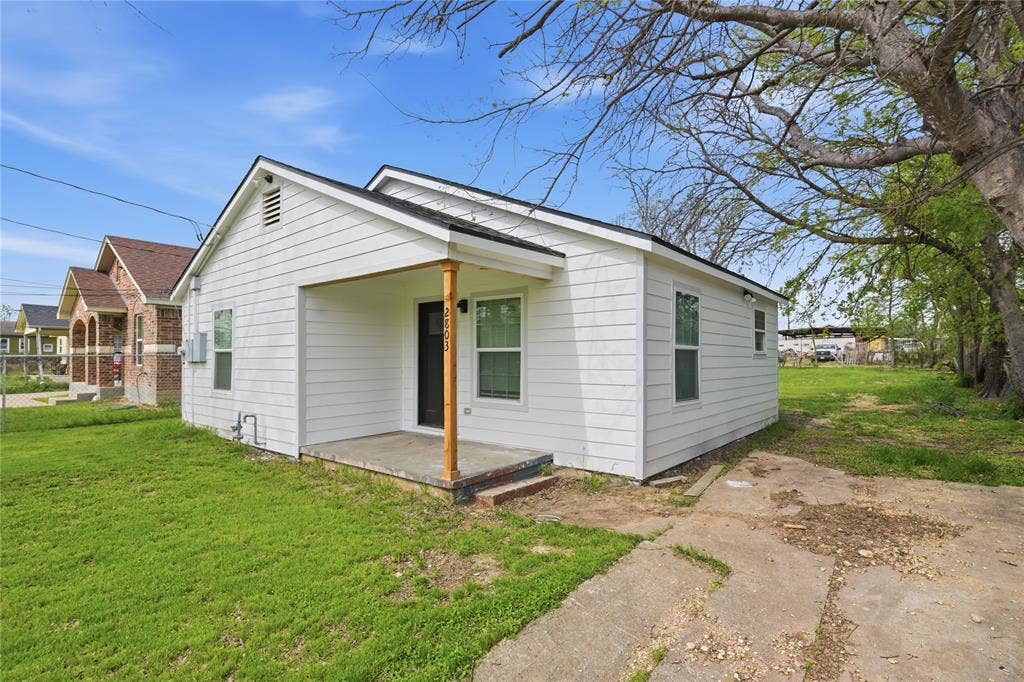 Exterior featuring horizontal white siding, a covered front porch with a wood support post, and a concrete driveway