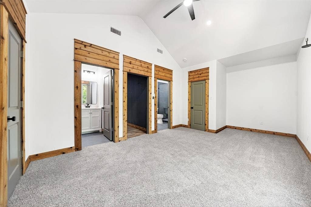 116 Carolynn Road, Mabank, TX 75156 Vaulted ceiling with a central paddle fan, custom wood door casing and header detail, neutral wall-to-wall carpeting, and solid-core interior doors