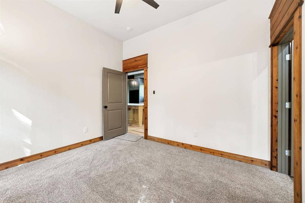 116 Carolynn Road, Mabank, TX 75156 Neutral-toned carpeting, natural wood-trimmed doorways, solid-core interior door, and ceiling fan