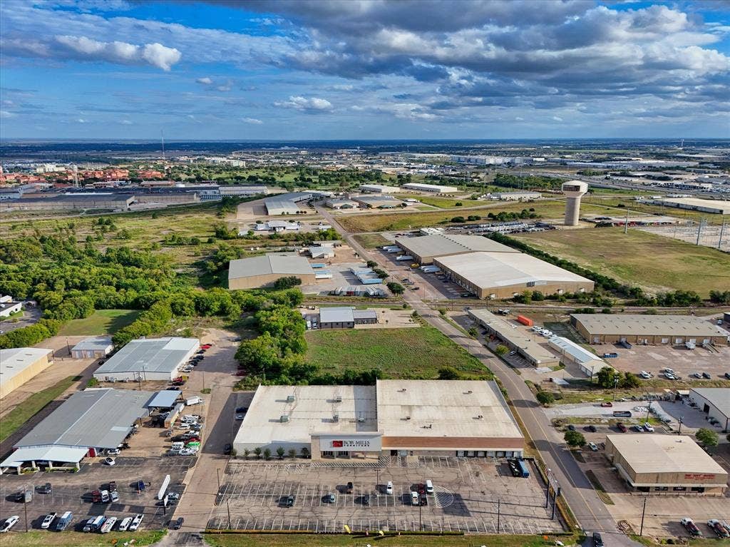 TBD Schroeder Drive, Waco, TX 76710 Industrial facility featuring an expansive paved parking area, multiple loading docks, and a flat-roofed commercial structure situated within an industrial corridor