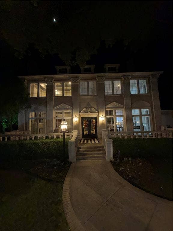 3011 Country Club Drive, McKinney, TX 75070 Two-story symmetrical exterior featuring classical columns, arched window detailing, stone balustrade, and a decorative entryway pediment