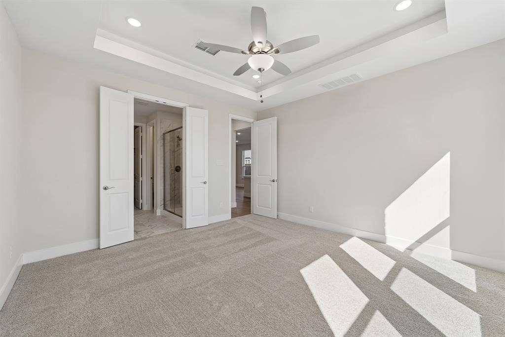 11512 Empress Drive, Frisco, TX 75035 Tray ceiling featuring recessed lighting and a central ceiling fan, neutral wall-to-wall carpeting, and solid-core interior doors