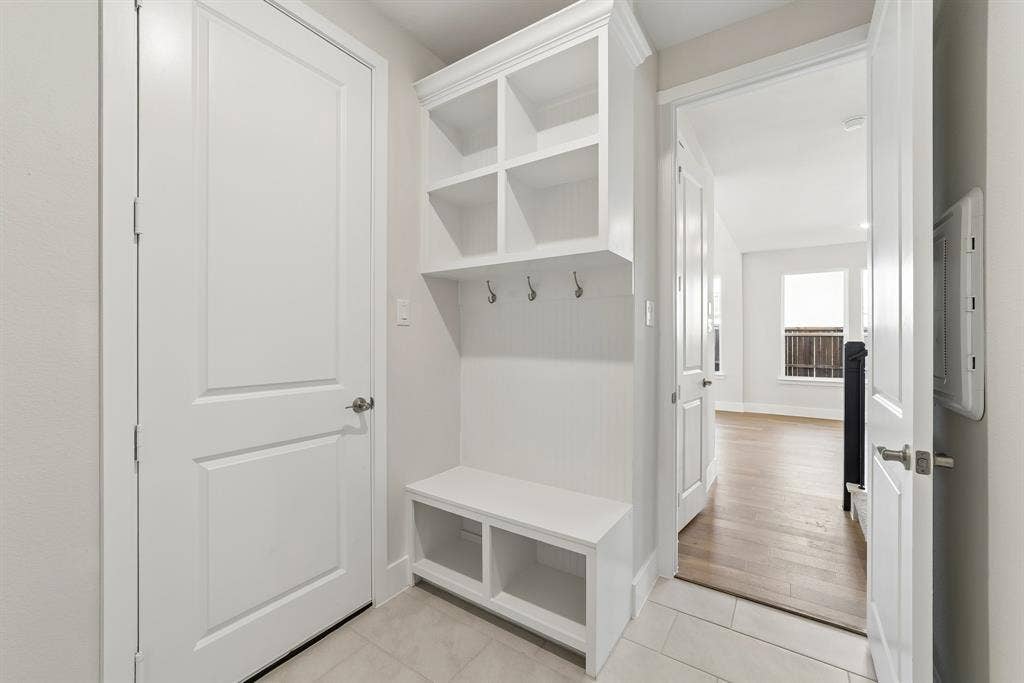 11512 Empress Drive, Frisco, TX 75035 Built-in white cabinetry featuring open overhead cubbies, integrated garment hooks, and a bench with lower storage compartments