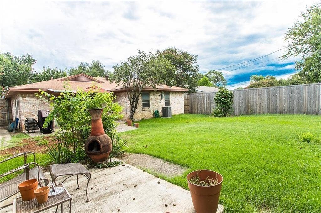 1217 Cloverdale Drive, Richardson, TX 75080 Backyard featuring a concrete patio, grassy lawn, and perimeter wood fencing