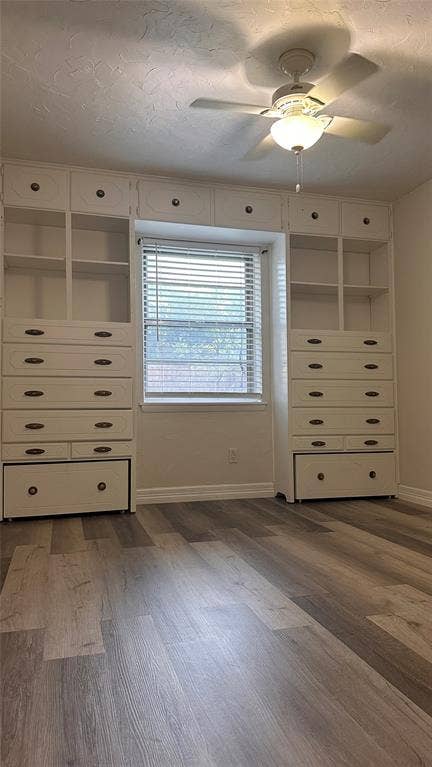 1217 Cloverdale Drive, Richardson, TX 75080 Built-in floor-to-ceiling cabinetry with overhead storage, wood-finish flooring, and a central ceiling fan with integrated lighting