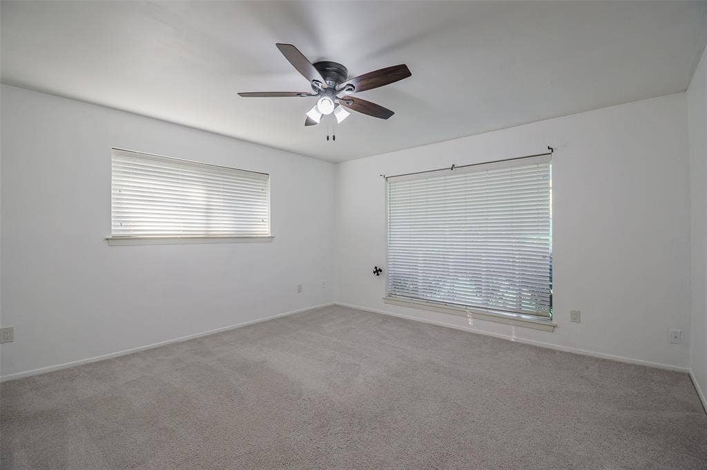 286 Larry Drive, Dallas, TX 75137 Neutral-toned wall finish, wall-to-wall carpeting, ceiling fan with integrated lighting, and horizontal window blinds