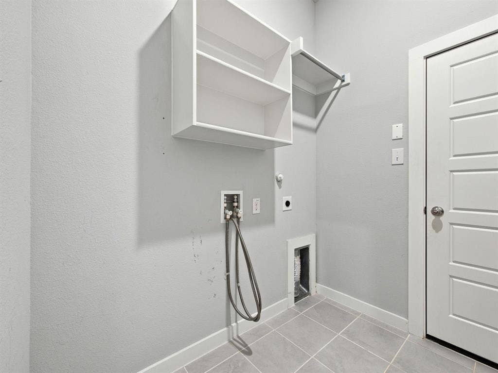 1157 Butterfly Dale Drive, Lavon, TX 75166 Utility space featuring tile flooring, built-in shelving, a garment rod, and washer and dryer hookups