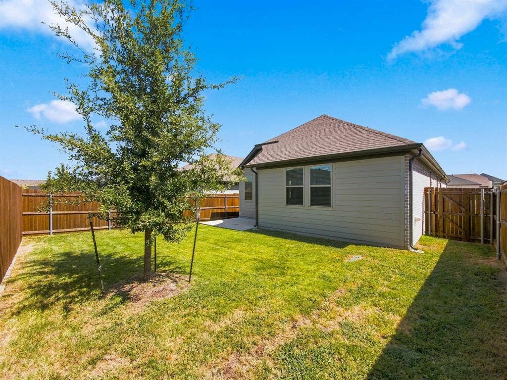 1157 Butterfly Dale Drive, Lavon, TX 75166 Backyard featuring a grass lawn, mature tree, concrete patio, and full-height wood fencing