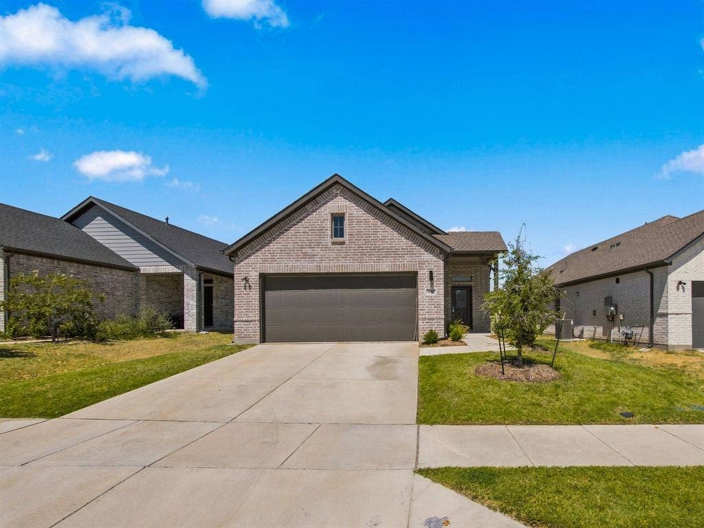 1157 Butterfly Dale Drive, Lavon, TX 75166 Brick exterior with gable roofline, attached multi-car garage, and concrete driveway
