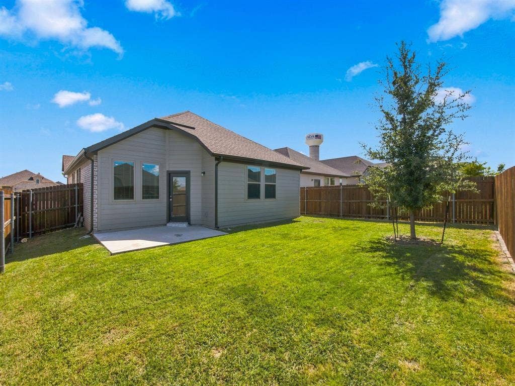 1157 Butterfly Dale Drive, Lavon, TX 75166 Rear exterior featuring horizontal lap siding, a concrete patio, and a fully enclosed backyard with wood privacy fencing