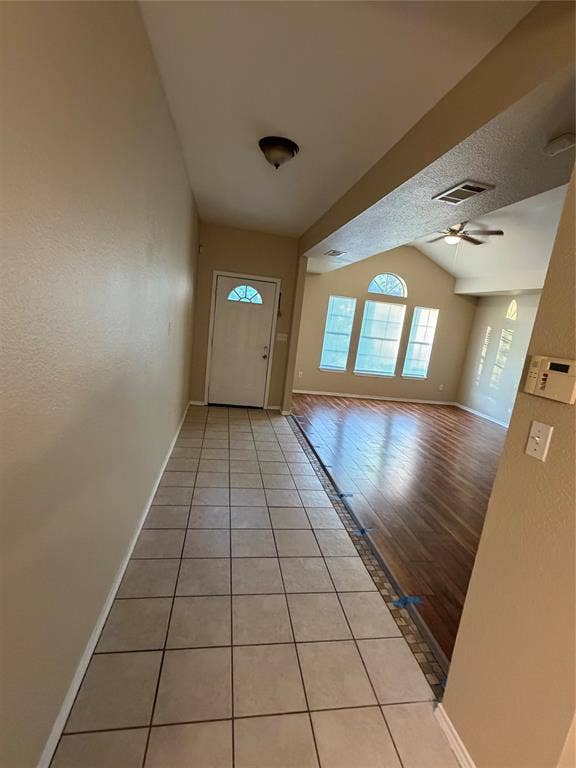 475 Perch Road, Rockwall, TX 75032 Entryway featuring square ceramic tile flooring, wood-finish flooring, vaulted ceilings, and multi-pane windows including an arched top transom