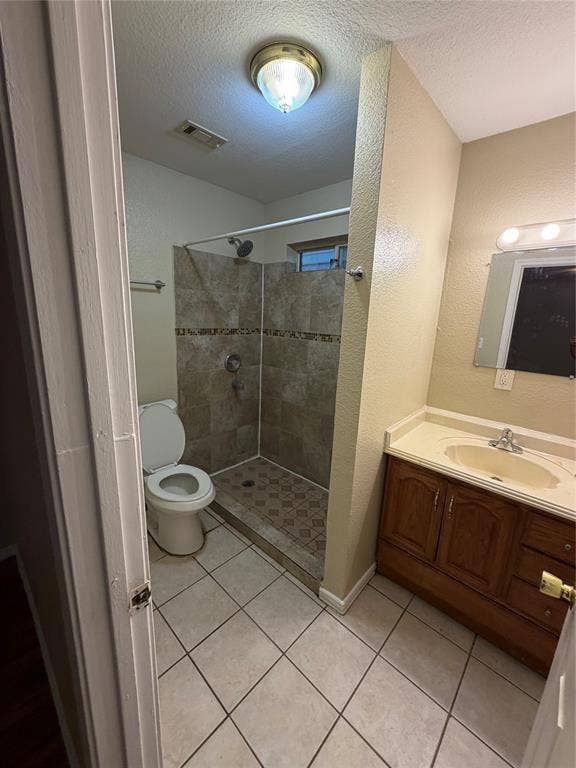 475 Perch Road, Rockwall, TX 75032 Bathroom featuring a walk-in shower with tile surround, wood-finish cabinetry, integrated sink countertop, and tiled flooring