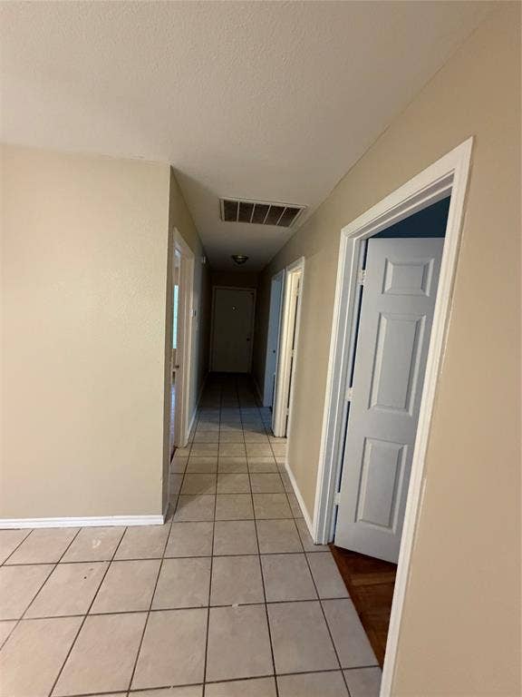 475 Perch Road, Rockwall, TX 75032 Neutral-toned interior hallway featuring large-format ceramic tile flooring, solid-core interior doors, and crisp white trim
