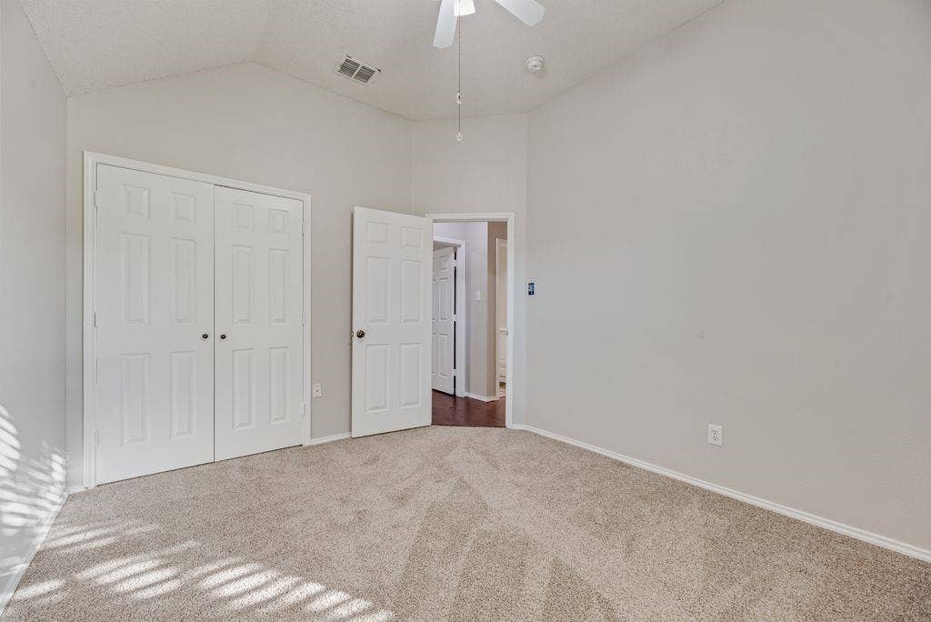 6310 Nueces Bay Drive, Rowlett, TX 75089 bedroom with ceiling fan and closet. Carpet installed October 2026