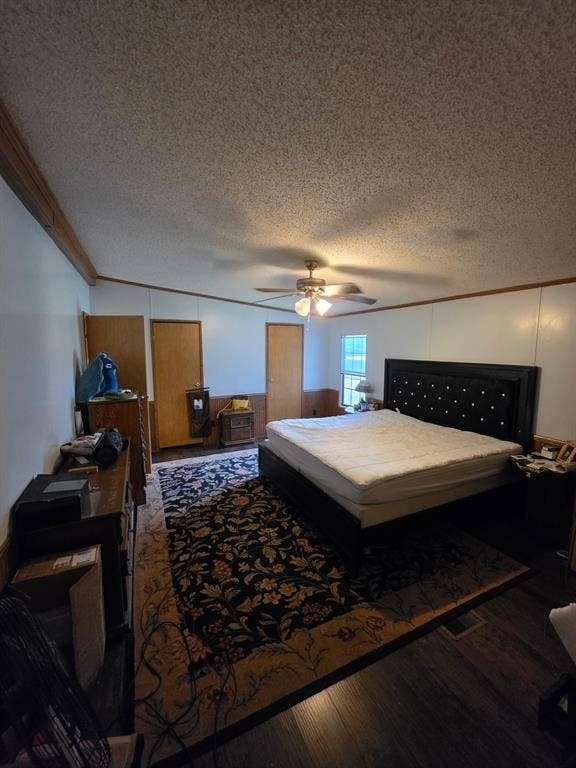 Vaulted ceiling featuring a central light fixture with an integrated ceiling fan, wood-finish flooring, and wood-trim accents