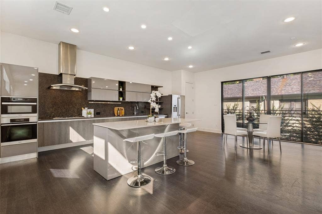 3336 Anchor Court, Dallas, TX 75219 Kitchen featuring high-gloss cabinetry, stone-finish countertops, stainless steel wall-mounted oven and microwave, recessed lighting, and wood-finish flooring