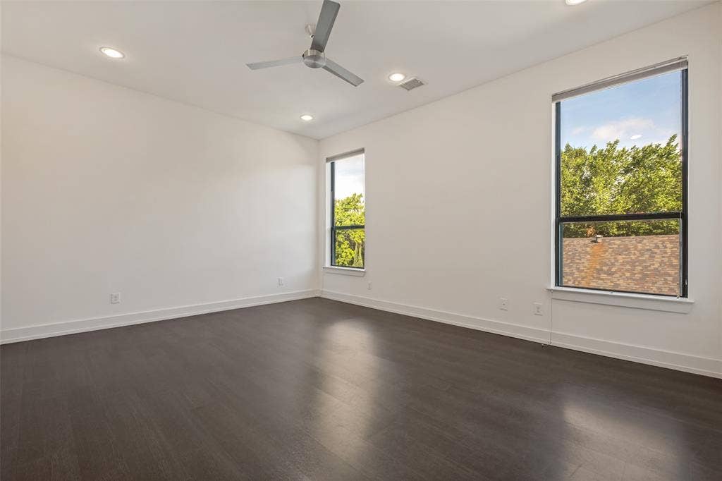 3336 Anchor Court, Dallas, TX 75219 Spacious room featuring high ceilings, dark wood-finish flooring, recessed lighting, a modern ceiling fan, and large windows with black frames