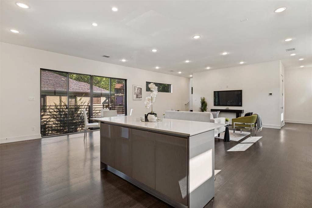 3336 Anchor Court, Dallas, TX 75219 Open floor plan featuring wood-finish flooring, recessed lighting, and a central kitchen island with a stone countertop