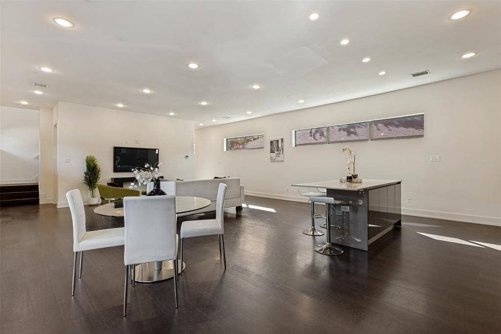 3336 Anchor Court, Dallas, TX 75219 Open-concept interior featuring wood-finish flooring, recessed lighting, horizontal clerestory windows, and a central island with a stone-top surface