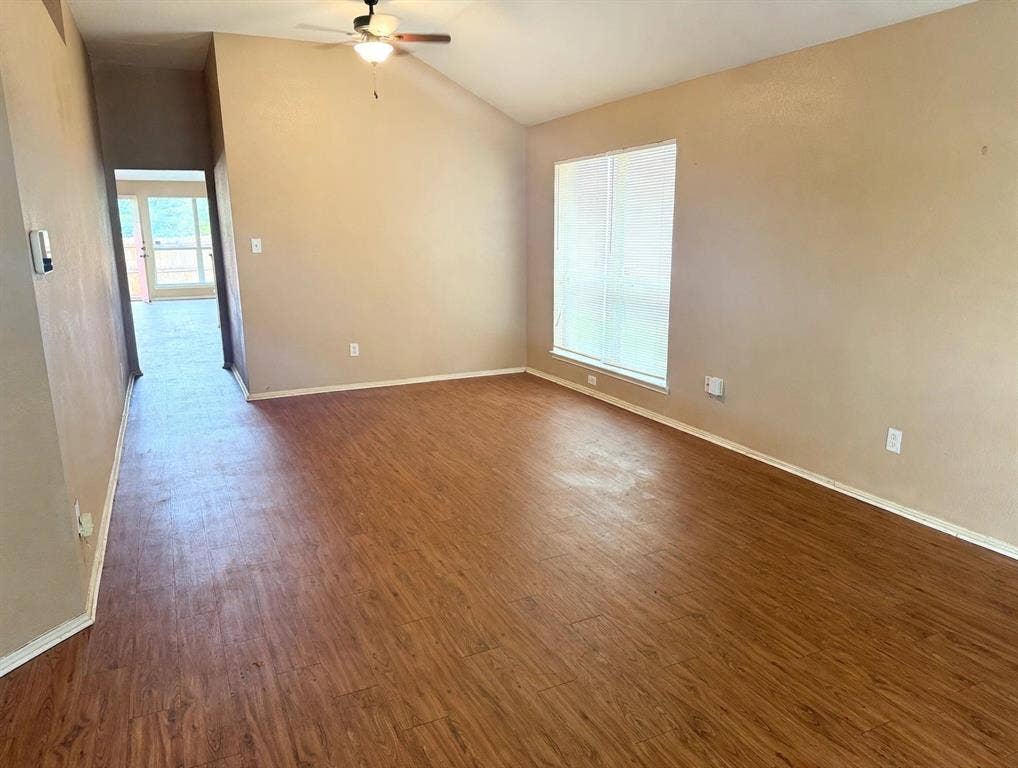 2053 Wild Creek Court, Dallas, TX 75253 Vaulted ceilings, wood-finish flooring, and a large window with neutral wall finishes and a ceiling-mounted light fixture