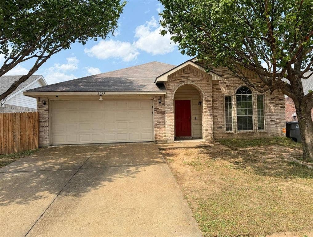 2053 Wild Creek Court, Dallas, TX 75253 Brick exterior featuring an arched entryway, shingle roofing, multi-pane windows, and a concrete driveway