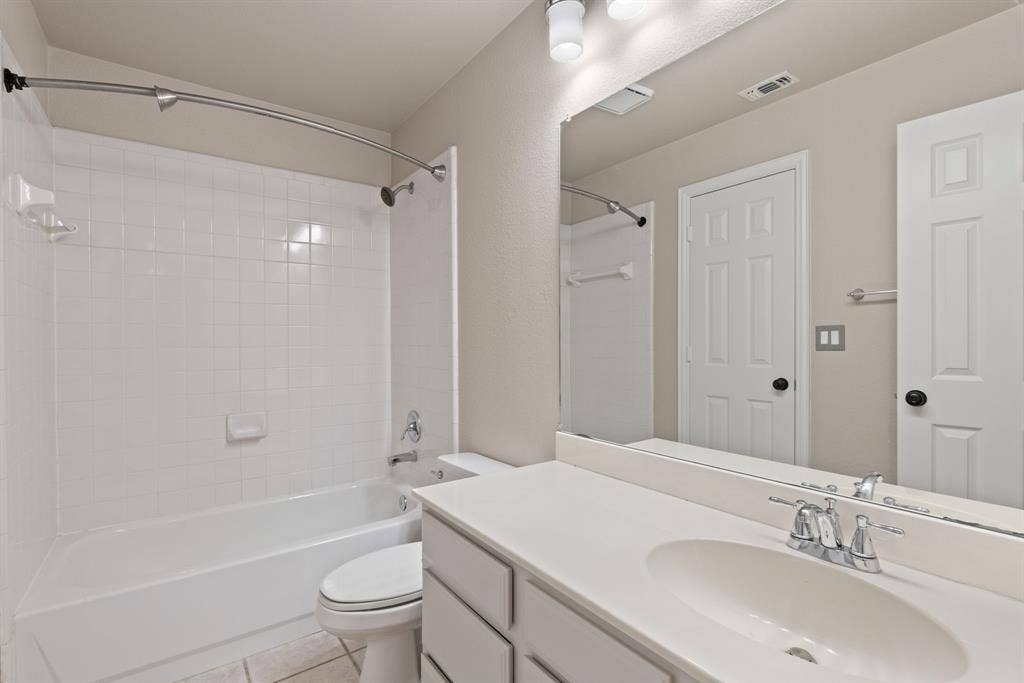 1110 Wedge Hill Road, McKinney, TX 75072 Full-width vanity with integrated sink, expansive wall-mounted mirror, white tile shower surround, curved shower rod, and two-panel interior door