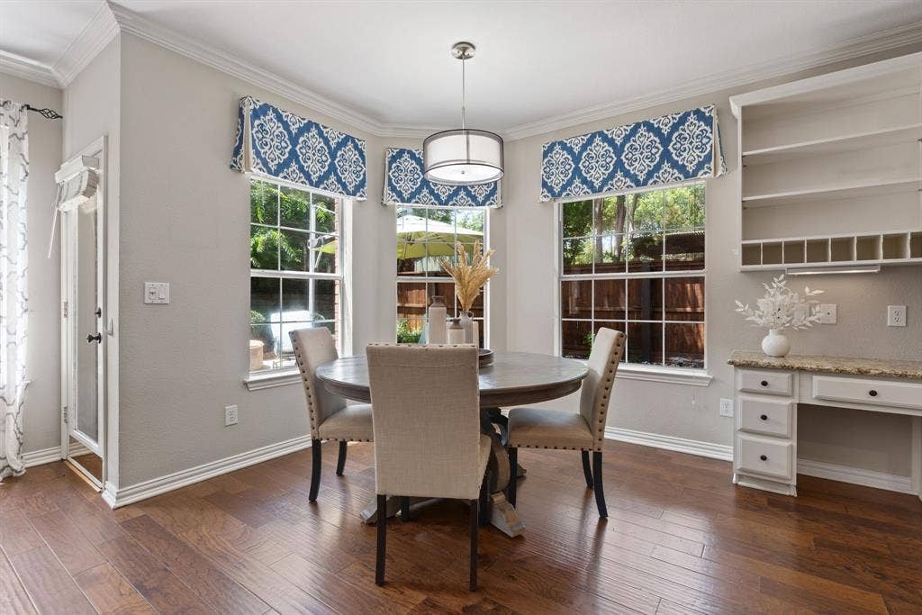 1110 Wedge Hill Road, McKinney, TX 75072 Bay window featuring divided-light windows, wood-finish flooring, built-in cabinetry with stone-surface desk, and a pendant light fixture