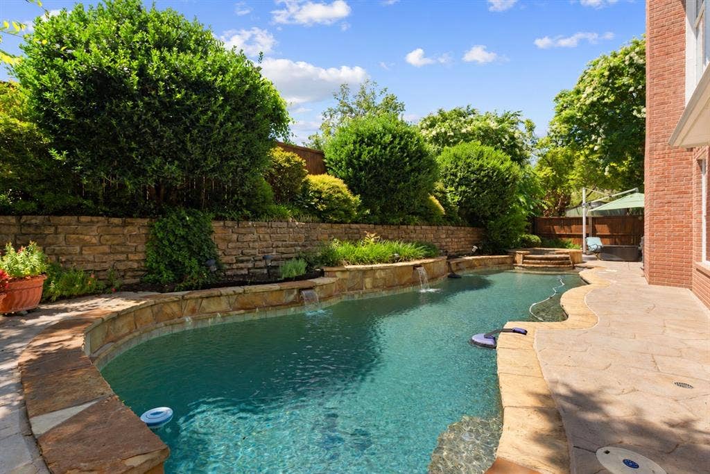 1110 Wedge Hill Road, McKinney, TX 75072 In-ground pool with stone coping, water features, flagstone patio, and tiered stone retaining walls