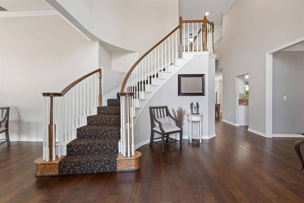 1110 Wedge Hill Road, McKinney, TX 75072 Grand foyer featuring a curved staircase with a wood handrail, white balusters, and a tiered landing