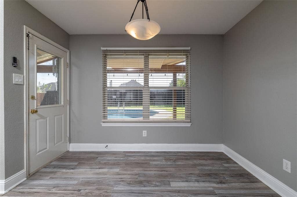 224 Cobblestone Circle, Red Oak, TX 75154 Wood-finish flooring, neutral wall tones, multi-pane window with horizontal blinds, glass-panel exterior door, and pendant lighting fixture