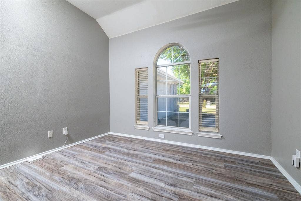 224 Cobblestone Circle, Red Oak, TX 75154 Vaulted ceilings featuring an arched window flanked by rectangular windows, finished with wood-finish flooring