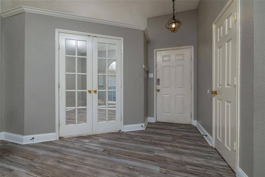 224 Cobblestone Circle, Red Oak, TX 75154 Entryway featuring wood-finish flooring, white paneled doors, dual glass-paneled French doors, and an orb-style pendant light fixture