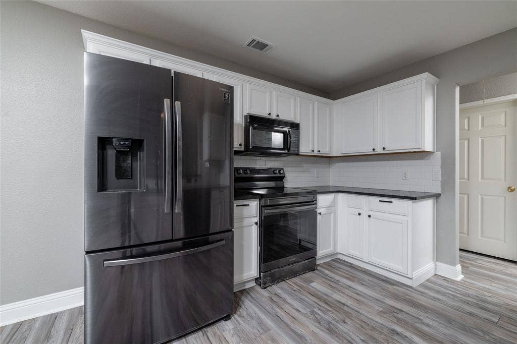 224 Cobblestone Circle, Red Oak, TX 75154 Kitchen featuring white shaker-style cabinetry, dark stone-finish countertops, wood-finish flooring, and black stainless steel appliances