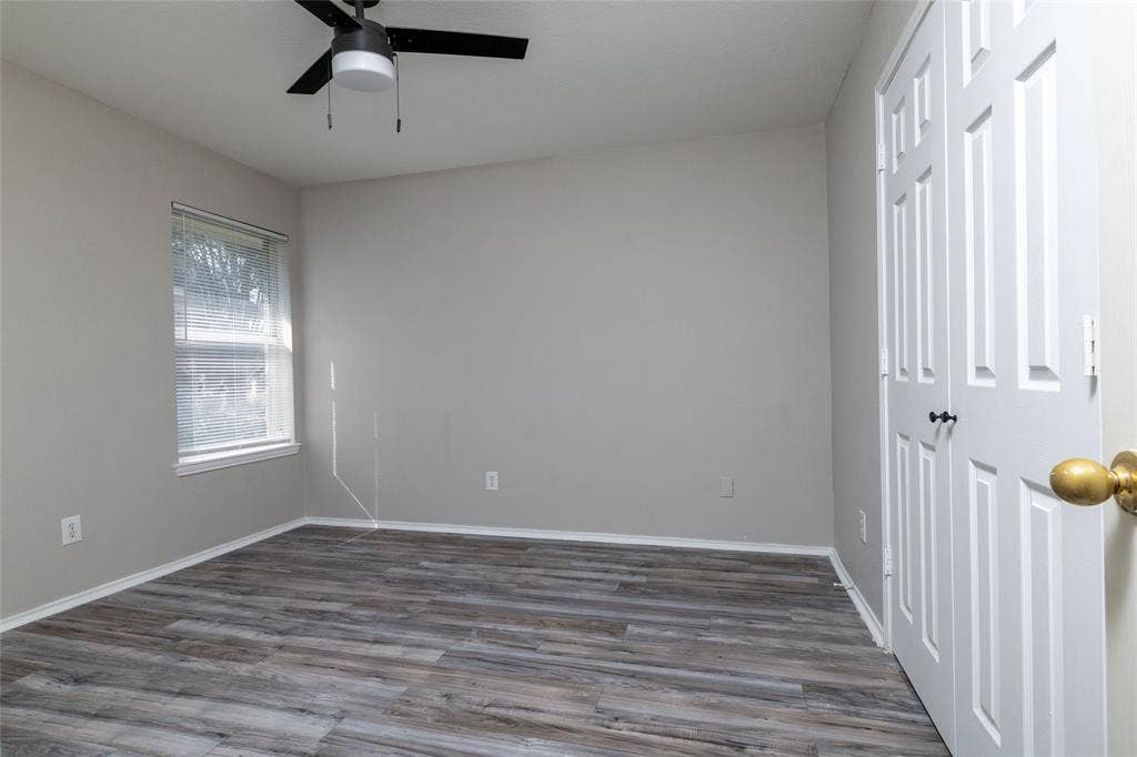 224 Cobblestone Circle, Red Oak, TX 75154 Neutral-toned walls paired with wood-finish flooring, a ceiling fan with integrated lighting, a dual-panel closet, and a single-hung window