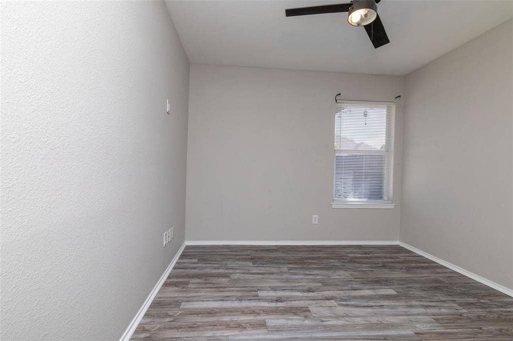 224 Cobblestone Circle, Red Oak, TX 75154 Neutral-toned room featuring wood-finish flooring, a single-light ceiling fan, and a window with integrated blinds