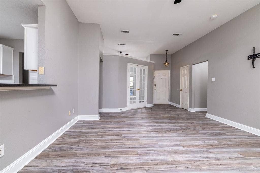 224 Cobblestone Circle, Red Oak, TX 75154 Open-concept interior featuring wood-finish flooring, recessed lighting, crown molding, double French doors, and a breakfast bar