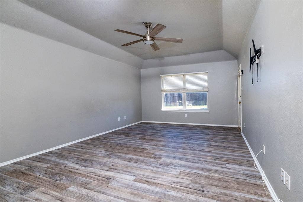 224 Cobblestone Circle, Red Oak, TX 75154 Trey ceiling featuring a central brushed-nickel ceiling fan, light-toned wood-finish flooring, and horizontal window blinds