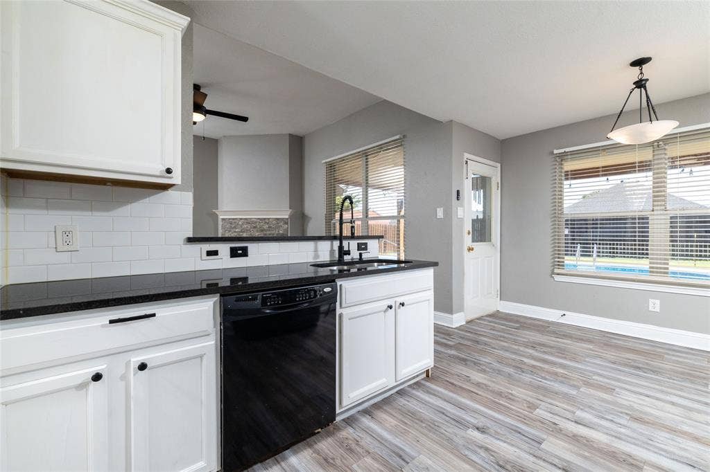 224 Cobblestone Circle, Red Oak, TX 75154 Kitchen featuring white shaker-style cabinetry, dark stone-finish countertops, white subway tile backsplash, matte black hardware, and wood-finish flooring