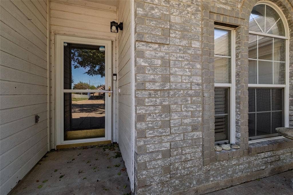 224 Cobblestone Circle, Red Oak, TX 75154 Covered entryway featuring a brick facade, horizontal siding, and a window with an arched transom