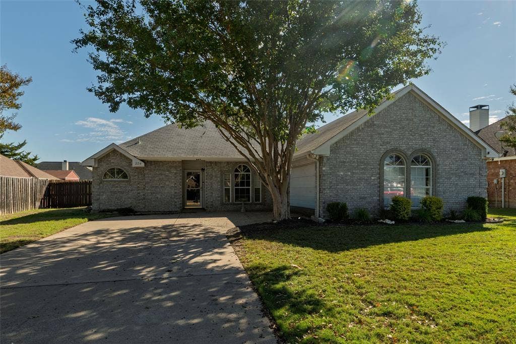 224 Cobblestone Circle, Red Oak, TX 75154 Single-story brick exterior featuring an arched window, a concrete driveway, a front-facing gable roof, and an attached garage
