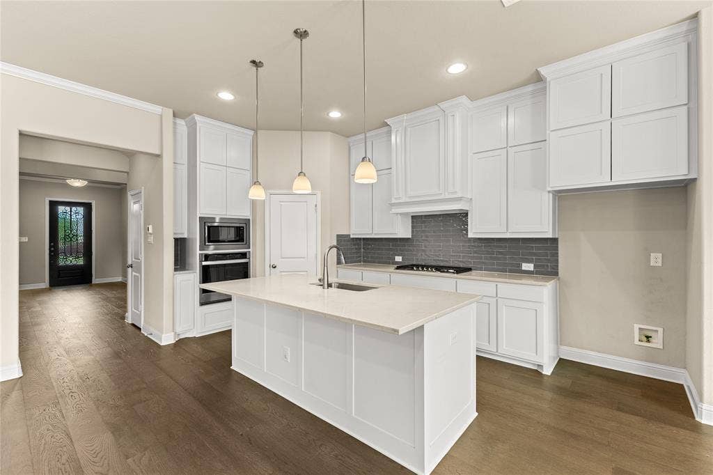 408 Abbott Lane, Waxahachie, TX 75165 Kitchen featuring white cabinetry, quartz countertops, a grey subway tile backsplash, built-in stainless steel double ovens, and a center island with pendant lighting