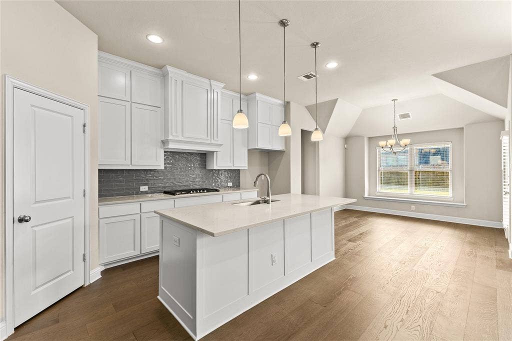 408 Abbott Lane, Waxahachie, TX 75165 Kitchen featuring white shaker-style cabinetry, quartz countertops, a grey subway tile backsplash, pendant lighting, and wood-finish flooring