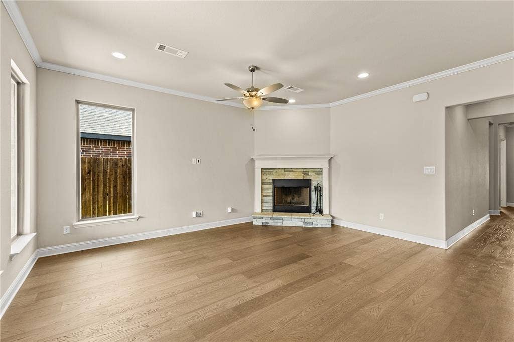408 Abbott Lane, Waxahachie, TX 75165 Wood-finish flooring throughout with a corner stone-accented fireplace, wood-burning hearth, ceiling fan with integrated lighting, and recessed ceiling illumination