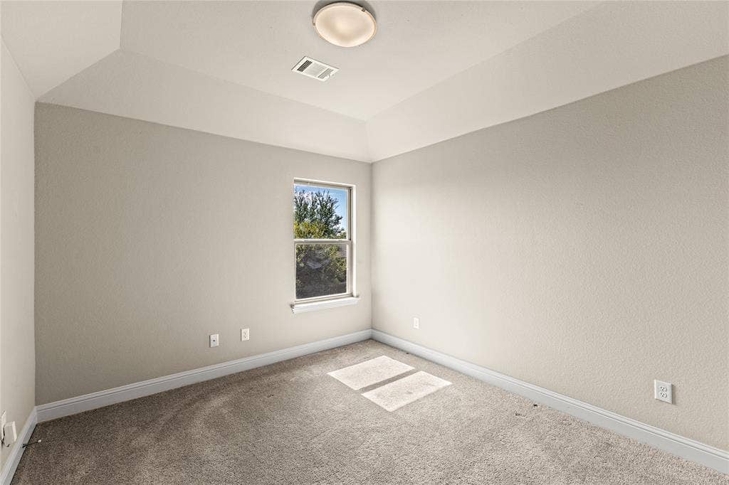 408 Abbott Lane, Waxahachie, TX 75165 Interior room featuring a tray ceiling, neutral wall tones, neutral wall-to-wall carpeting, and a single window