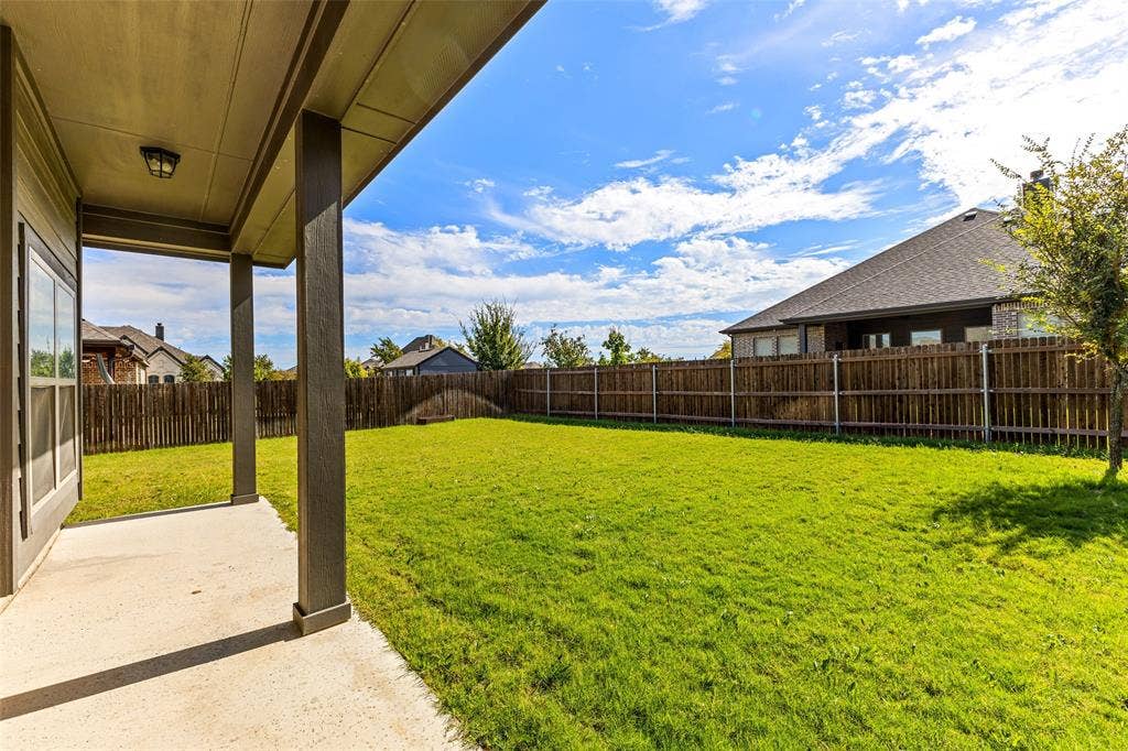 408 Abbott Lane, Waxahachie, TX 75165 Covered concrete patio with square support columns, fenced backyard, and established lawn