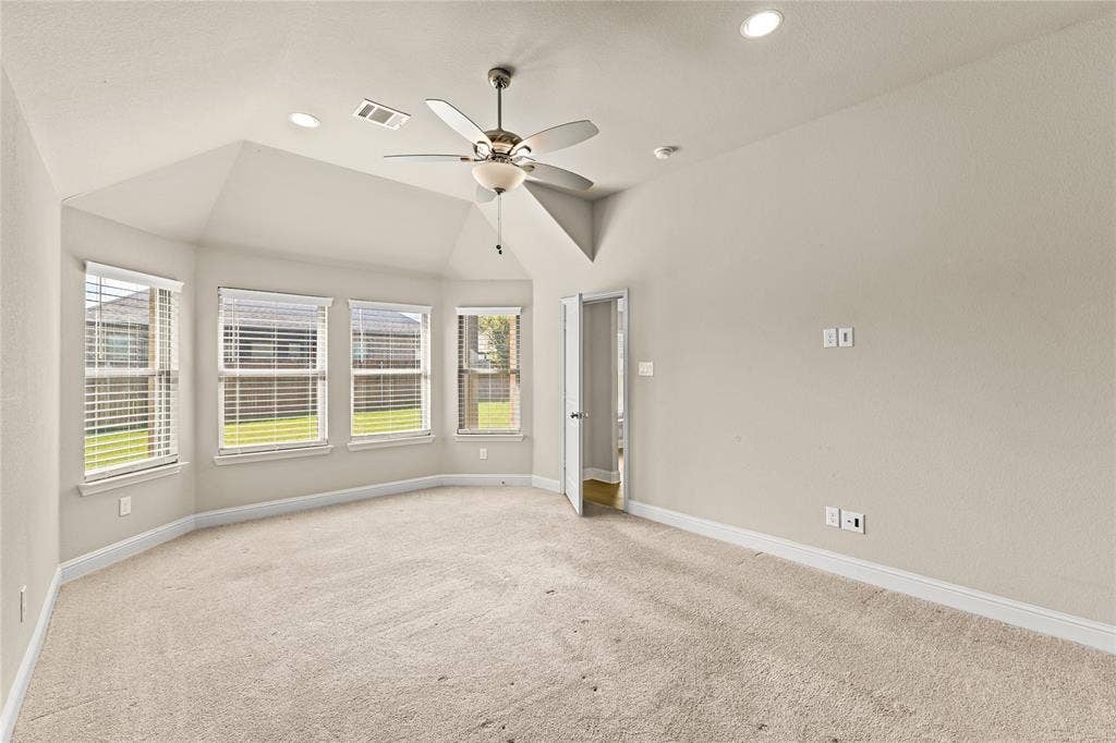 408 Abbott Lane, Waxahachie, TX 75165 Vaulted ceiling with a centrally mounted ceiling fan, neutral wall-to-wall carpeting, multiple windows providing natural light, and recessed lighting