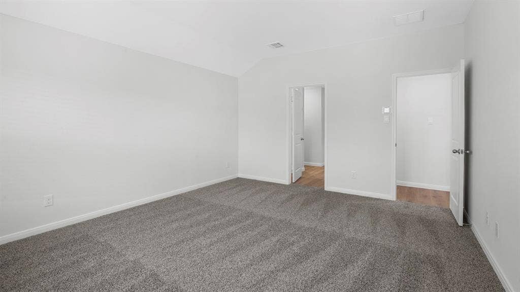 320 Ridan Drive, Waxahachie, TX 75165 Spacious interior room featuring light gray carpeting, neutral wall finishes, white baseboards, and two doorways